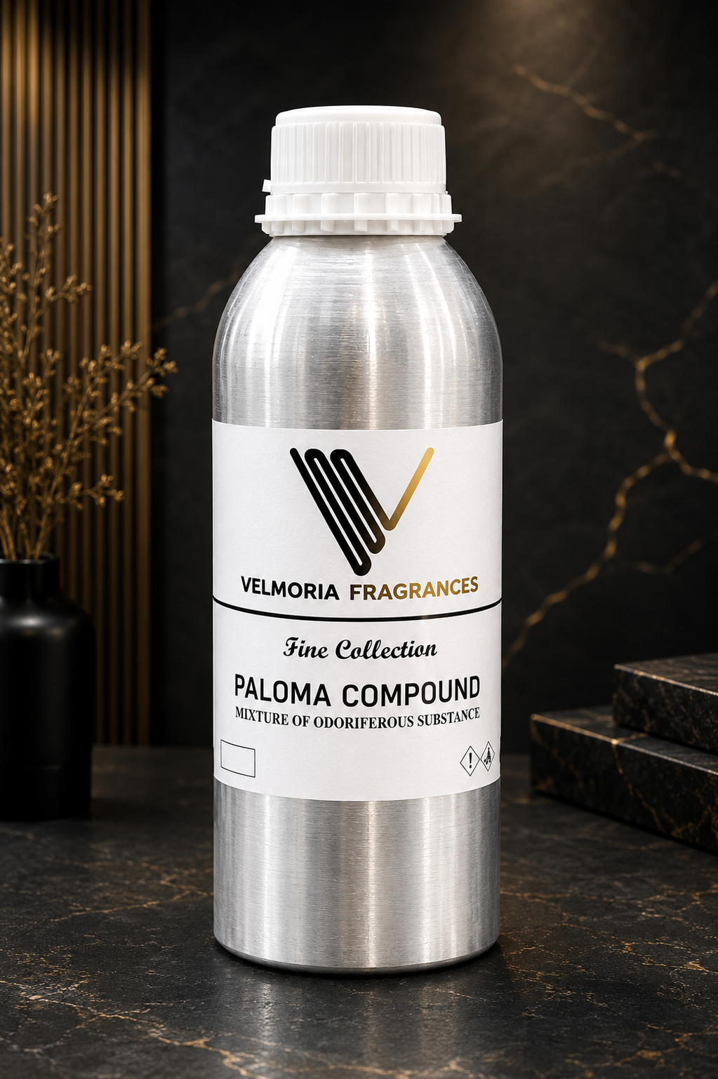 A silver aluminum bottle of Velmoria Fragrances Paloma Compound, a mixture of odorous substances, set against a dark marble background with gold veining and a black vase with dried branches.
